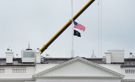Opuszczona do połowy flaga USA nad Białym Domem.
