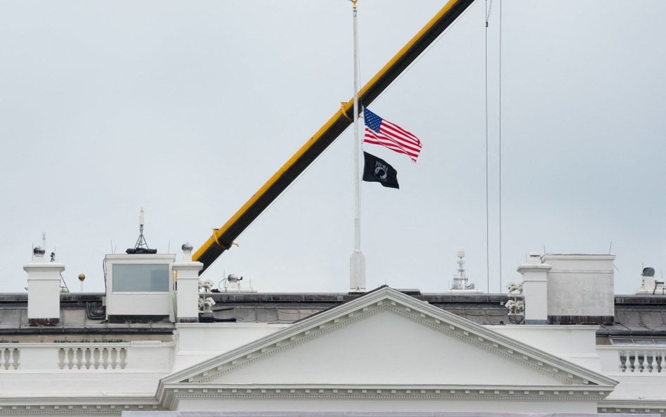 Opuszczona do połowy flaga USA nad Białym Domem.