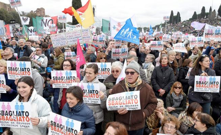 Demonstranci w Circo Massimo trzymający plakaty z napisem „Złe i złe”