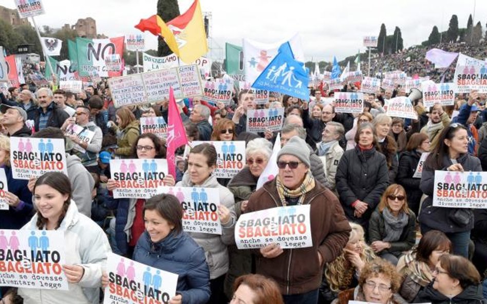 Demonstranci w Circo Massimo trzymający plakaty z napisem „Złe i złe”