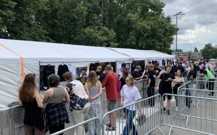 Fani przy stoiskach z pamiątkowymi gadżetami artysty