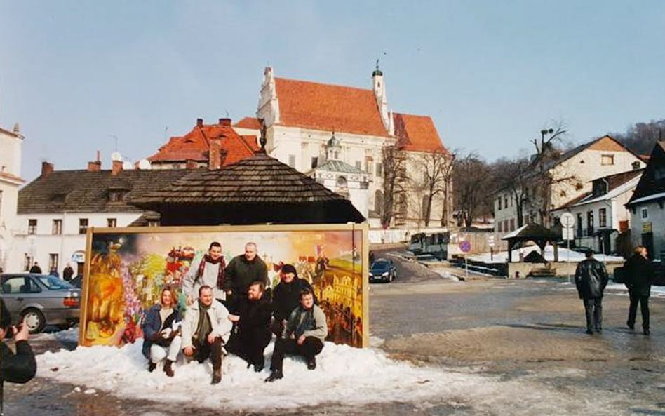 Współtwórcy obrazu na tle swego dzieła. Reprodukcja poniżej.