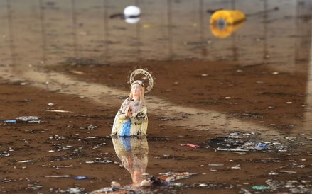 Figurka Matki Bożej z Lourdes pływająca wśród odpadów na zalanej ulicy w Mandelieu-la-Napoule w połu