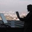 Ukrainka korzysta z systemu łączności internetowej przez satelity Starlink na dachu budynku w Kijowi