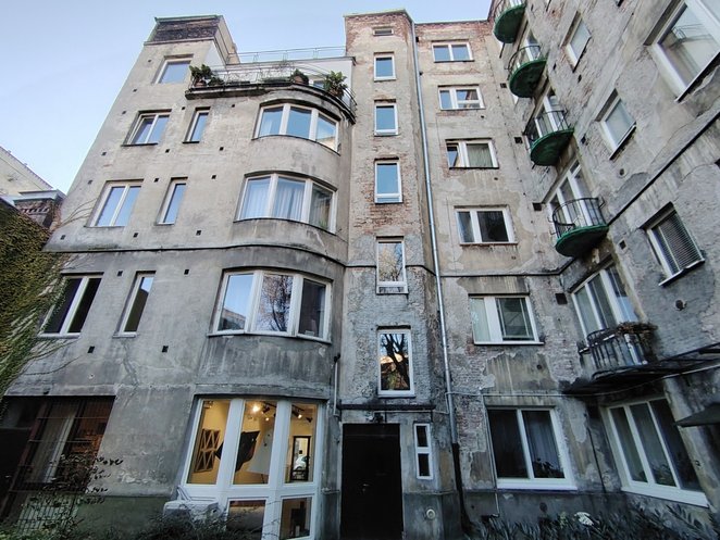 Od strony podwórka uwagę zwracają natomiast płytkie płyty balkonów zamknięte łukiem, co nadaje bryle