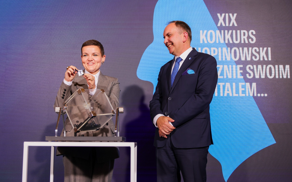 Ministra Marta Cienkowska losuje kolejność występu na Konkursie Chopinowskim, obok dyr. Artur Szklen