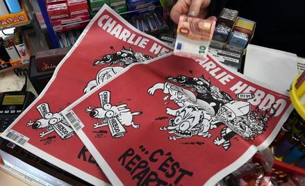 Kobieta płaci za najnowszy numer satyrycznego tygodnika "Charlie Hebdo"