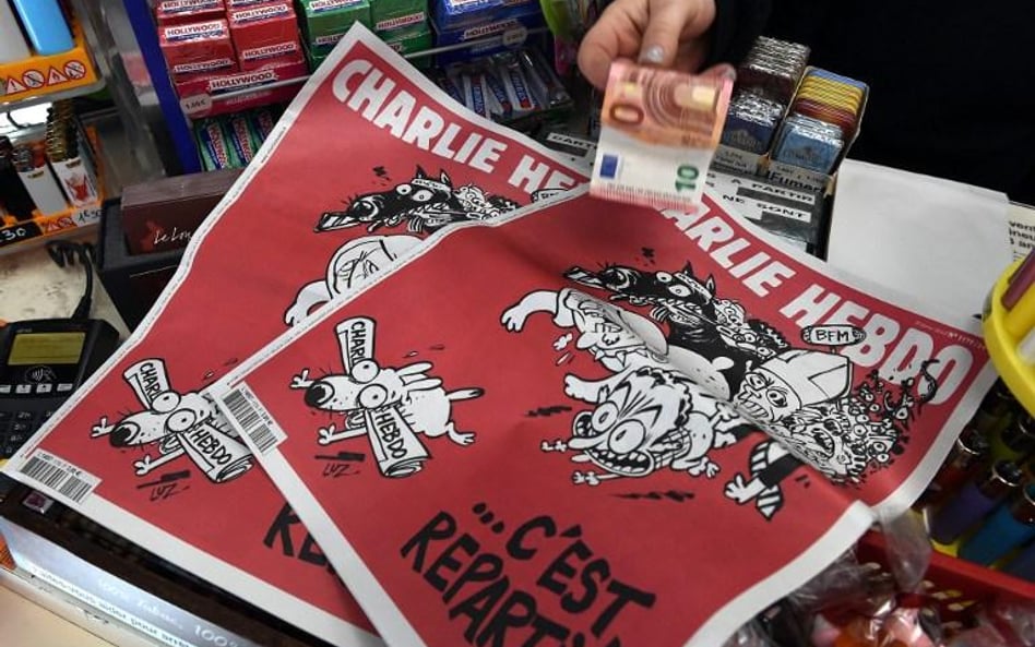 Kobieta płaci za najnowszy numer satyrycznego tygodnika "Charlie Hebdo"