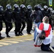 Białorusinka klęczy przed funkcjonariuszami OMON podczas wiecu w Mińsku, 13 września