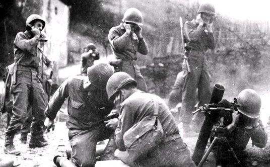 Amerykańscy żołnierze ostrzeliwujący pozycje niemieckie w czasie walk w Ardenach