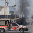 Pojazd sił paramilitarnych na ulicy w Karaczi, w tle widać dym po protestach przed amerykańskim kons
