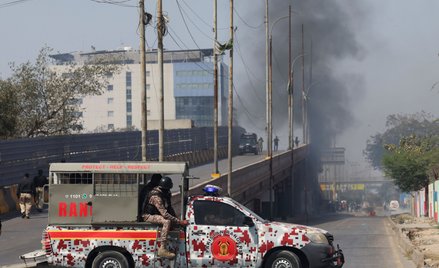 Pojazd sił paramilitarnych na ulicy w Karaczi, w tle widać dym po protestach przed amerykańskim kons