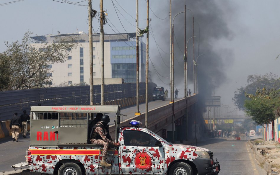 Pojazd sił paramilitarnych na ulicy w Karaczi, w tle widać dym po protestach przed amerykańskim kons