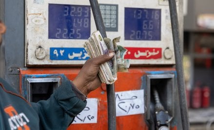 Pracownik stacji benzynowej obsługiwanej przez CPC-Egypt w Kairze z garścią banknotów w funtów egips