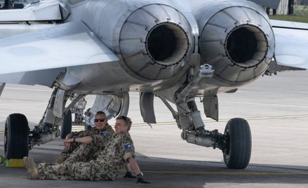 Amerykańscy żołnierze odpoczywają w cieniu myśliwca w bazie lotniczej w Ramstein.