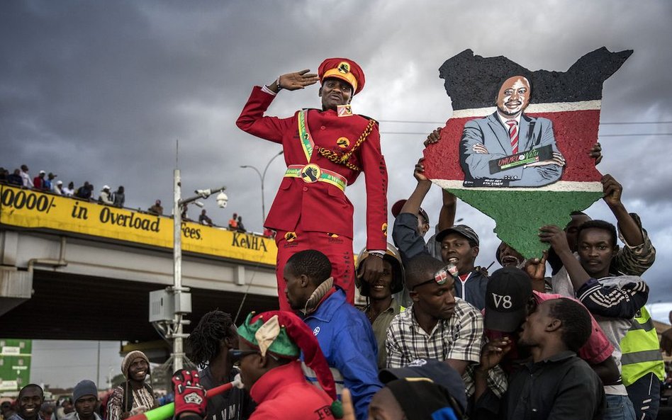 Zwolennik prezydenta Kenii Uhuru Kenyatta pozdrawiający ludzi w Nairobi.