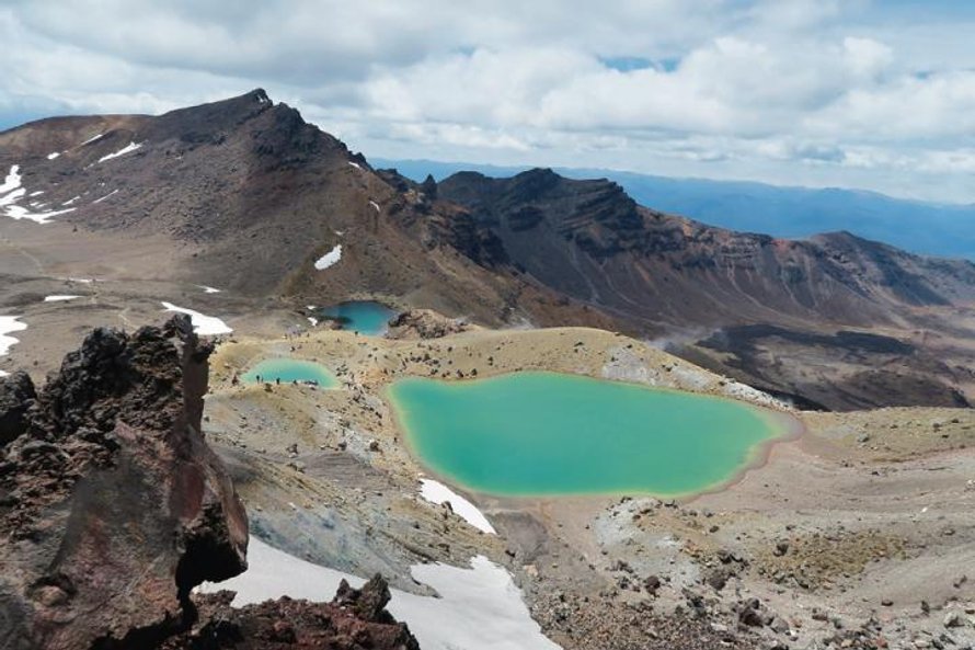 Szmaragdowe jeziora jak magnes przyciągają piechurów na szlak w Parku Narodowym Tongariro.