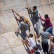 Migranci wspinają się na wał morski w marokańskim mieście Fnideq po nieudanej próbie przekroczenia g
