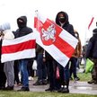Protestujący w Mińsku trzymają opozycyjne biało-czerwono-białe flagi, historyczny symbol Białorusi