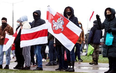 Protestujący w Mińsku trzymają opozycyjne biało-czerwono-białe flagi, historyczny symbol Białorusi