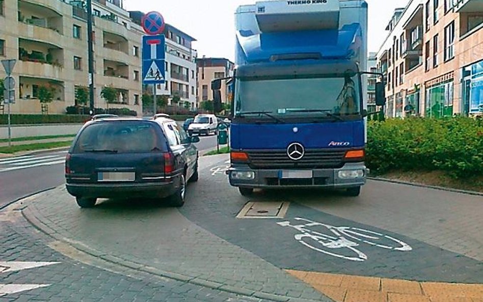 Miasteczko Wilanów. Rowerzysta przeciśnie się między autami. Pieszemu zostaje jezdnia