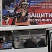 Autobus komunikacji miejskiej w Doniecku przejeżdżający pod plakatem miejscowego centrum rekrutacyjn