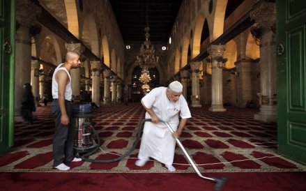 Palestyńczycy sprzątają po zamieszkach, które wybuchły w ubiegłą niedzielę między izraelską policją 