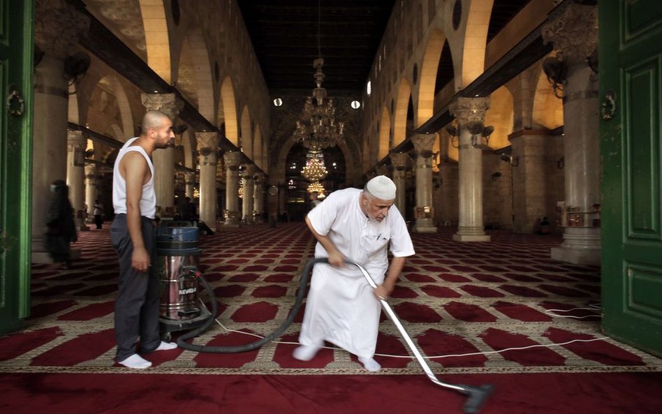 Palestyńczycy sprzątają po zamieszkach, które wybuchły w ubiegłą niedzielę między izraelską policją 