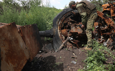 Ukraiński żołnierz przy zniszczonym rosyjskim czołgu