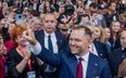 Karol Nawrocki w czasie kampanii. Za nim - szef jego ochrony ppłk Radziwon