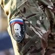 Rosyjski żołnierz z naszywką, na której widać twarz Władimira Putina