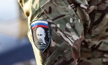 Rosyjski żołnierz z naszywką, na której widać twarz Władimira Putina