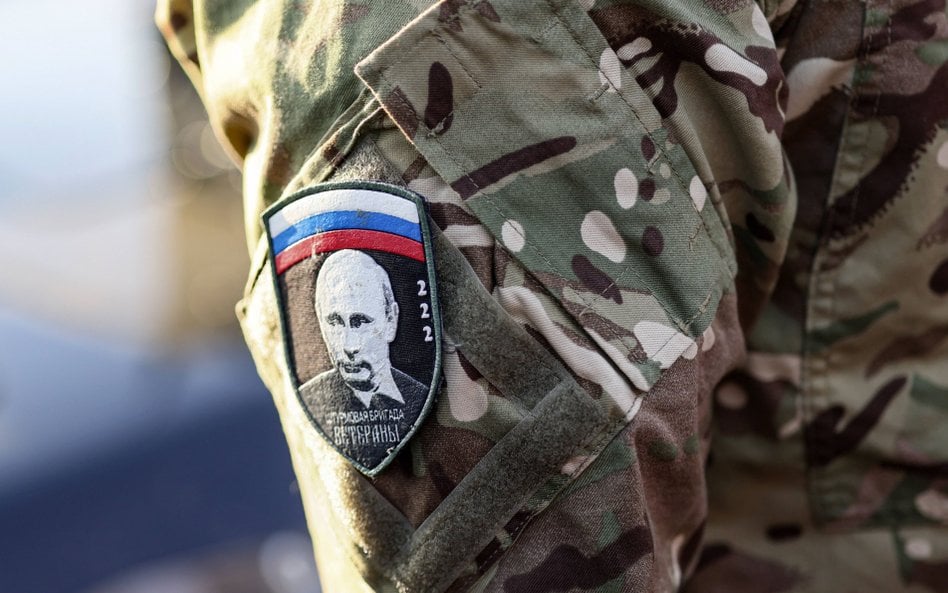 Rosyjski żołnierz z naszywką, na której widać twarz Władimira Putina
