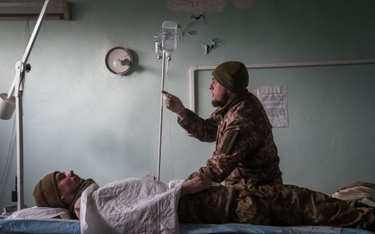 Wojskowy ratownik medyczny zajmuje się lekko rannym ukraińskim żołnierzem