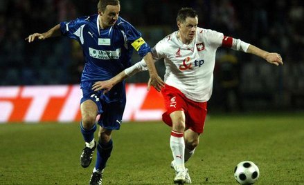 O piłkę walczą Jacek Krzynówek (Z prawej) i Aleksandar Vukovic.