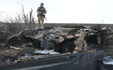 Ukraiński żołnierz przy spalonym rosyjskim czołgu