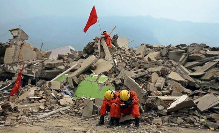 Ratownicy odpoczywają na gruzach budynku w prowincji Syczuan. Wciąż trwają poszukiwania ocalałych os