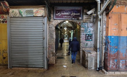 Ludzie spacerują ulicą na Starym Mieście w Jerozolimie po wprowadzeniu ograniczeń dotyczących dużych