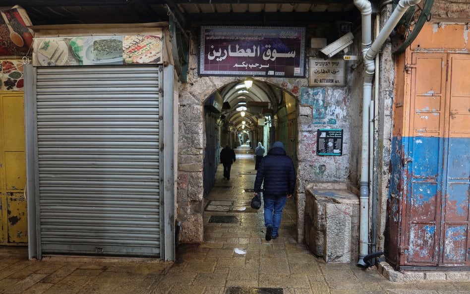 Ludzie spacerują ulicą na Starym Mieście w Jerozolimie po wprowadzeniu ograniczeń dotyczących dużych