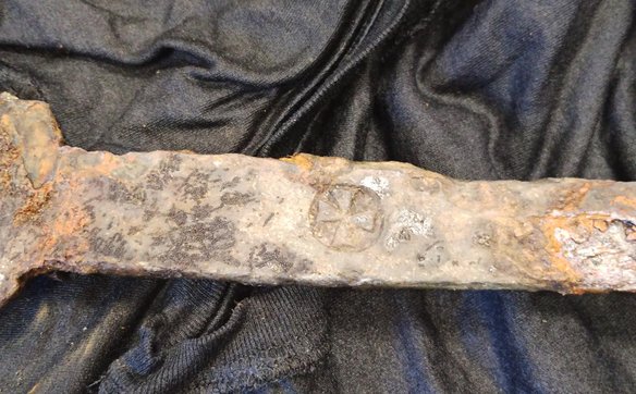 Znak w formie krzyża na trzonie miecza