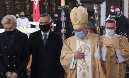 Prezydent Andrzej Duda z małżonką oraz biskup pomocniczy warszawski Michał Janocha składają kwiaty p