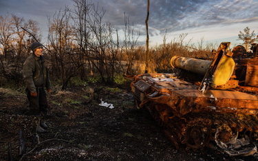 Ukrainiec ogląda zniszczony rosyjski czołg
