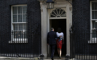 Premier Wielkiej Brytanii David Cameron z małżonką wchodzą na Downing Street 10 po wygłoszeniu oświa