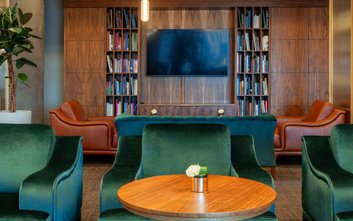 Kącik w salonie VIP przypominający domową bibliotekę, idealny do pracy w skupieniu lub cichego wypoc
