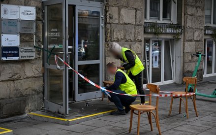 Śledczy zabezpieczają ślady przed wejściem do budynku przy ulicy Wiejskiej w Warszawie