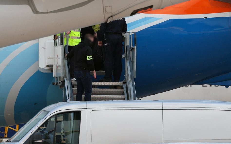 Funkcjonariusze policji opuszczają samolot linii lotniczej Flydubai po wylądowaniu na lotnisku Okęci
