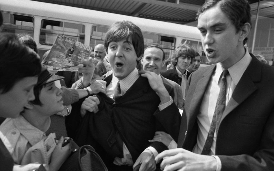 Paul McCartney (w centrum) i George Harrison (w tle) na lotnisku Orly w Paryżu w 1965 r.