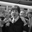 Paul McCartney (w centrum) i George Harrison (w tle) na lotnisku Orly w Paryżu w 1965 r.