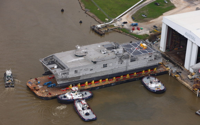 Symboliczne wodowanie – wyprowadzenie na barce z hali montażowej – szybkiego transportowca USNS Newp