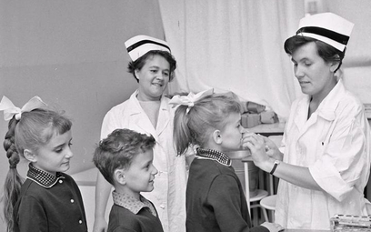 Pielęgniarka podaje dziecku doustną szczepionkę przeciw polio. Warszawa, 1968 r.
